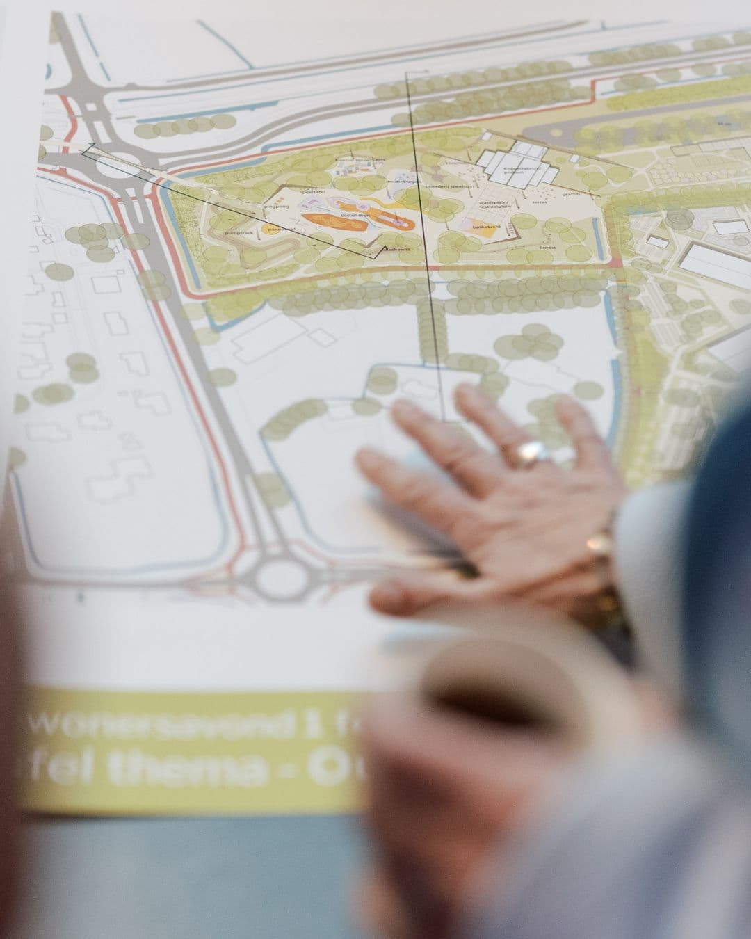 Foto van een hand op een geprinte tekening van het landschappelijk ontwerp van USPA tijdens een inspraakavond